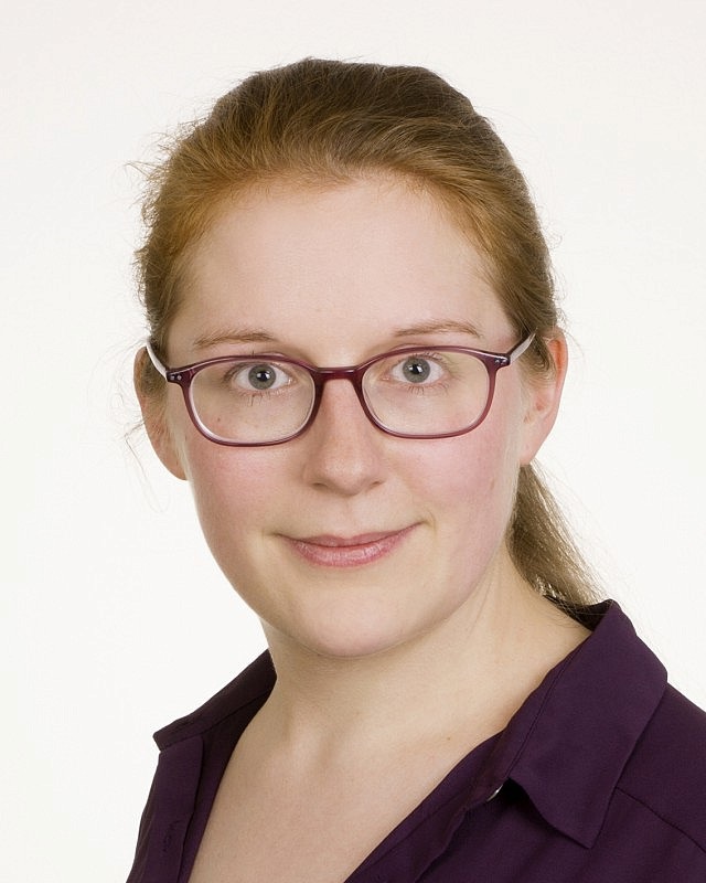 Headshot of Laura Nerbl from the shoulders up beaming in a business casual top